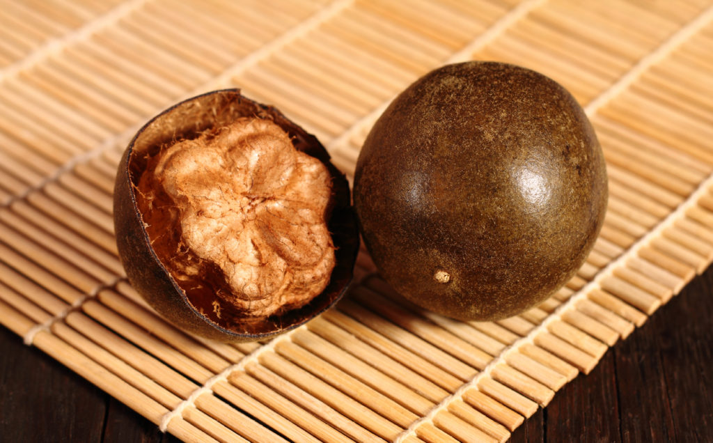 Luo Han Guo with bamboo mat on the wooden background